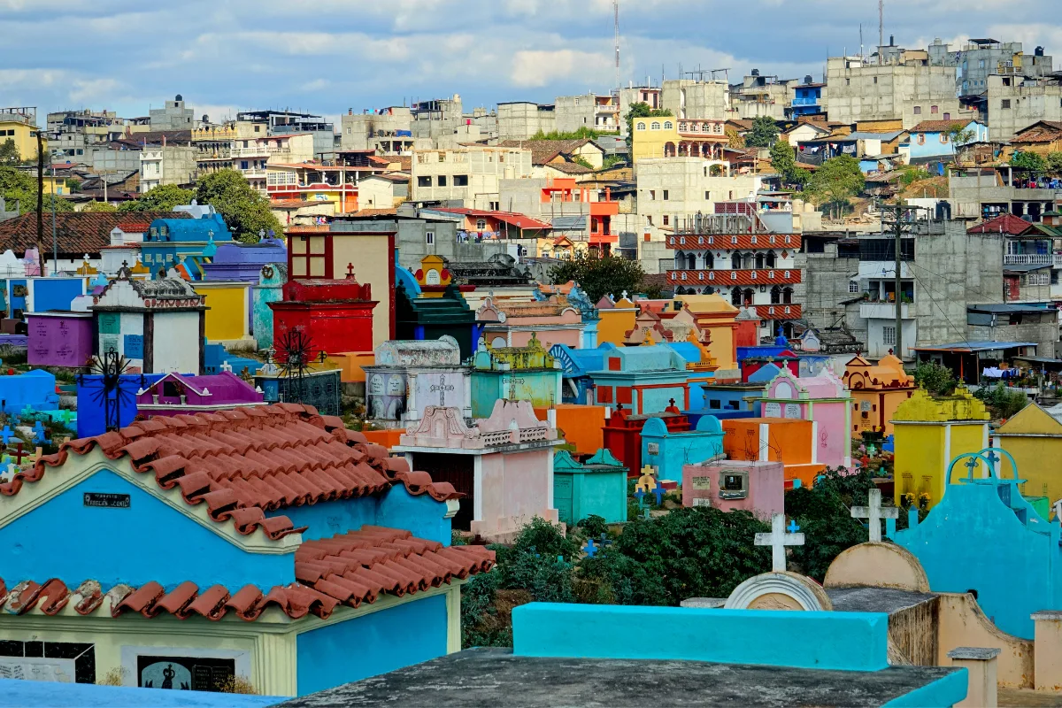 Inexpensive Places to Travel, Vibrant cemetery with colorful tombs and buildings in Guatemala City.