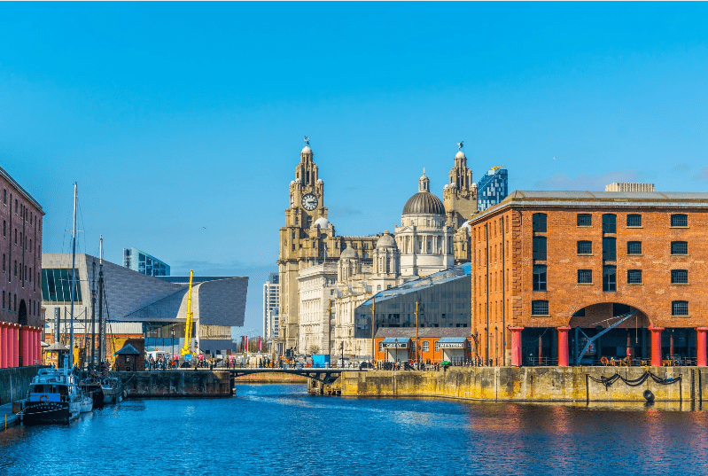 Unesco World Heritage Sites in England, View of the Liverpool waterfront featuring historic buildings and a canal with boats.